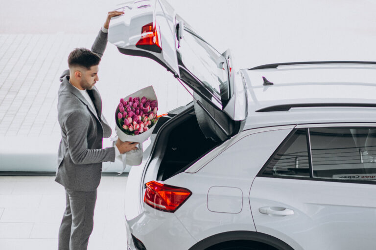 Young handsome business man delivering bouquet of beautiful flowers